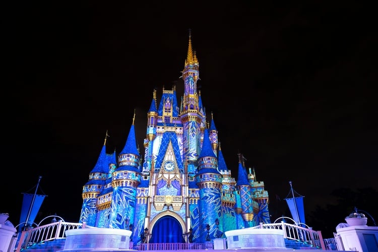 A lit up Frozen display on Cinderella's castle, part of Disney World Christmas Party 2023